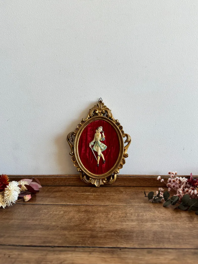 Figurine sur fond de velours rouge encadrement rococo doré