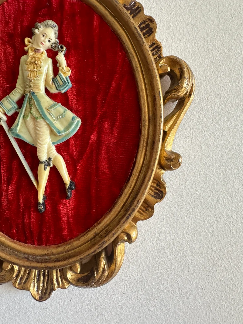 Figurine sur fond de velours rouge encadrement rococo doré