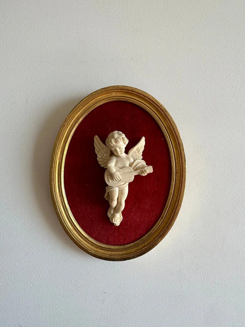 Angelot encadré de bois sur velours rouge