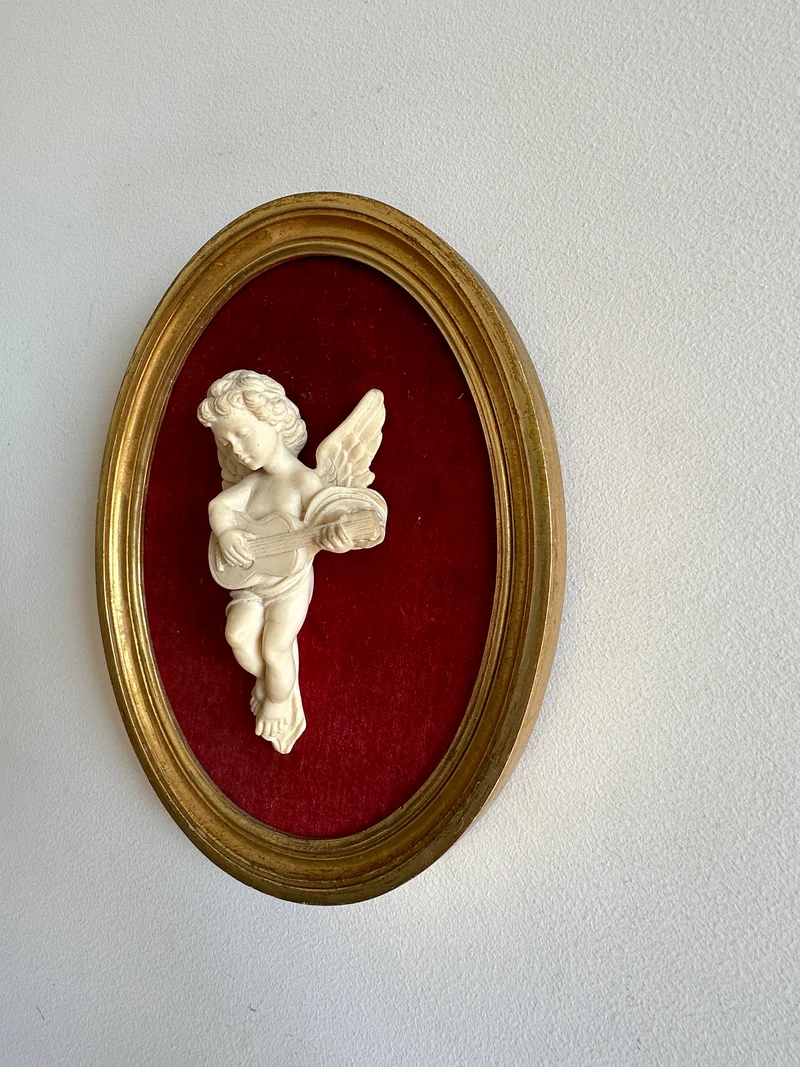 Angelot encadré de bois sur velours rouge