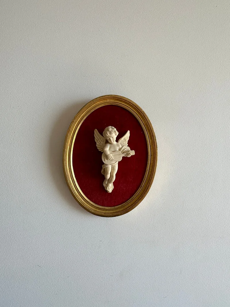 Angelot encadré de bois sur velours rouge