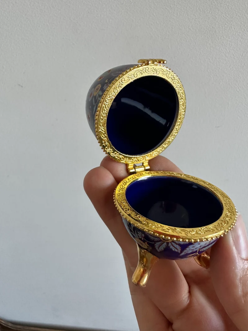 Oeuf en porcelaine sur pieds dorés