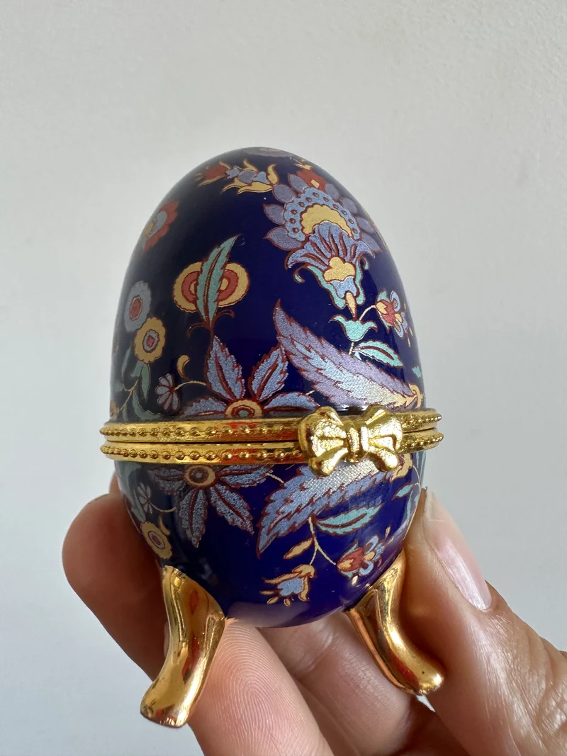 Oeuf en porcelaine sur pieds dorés