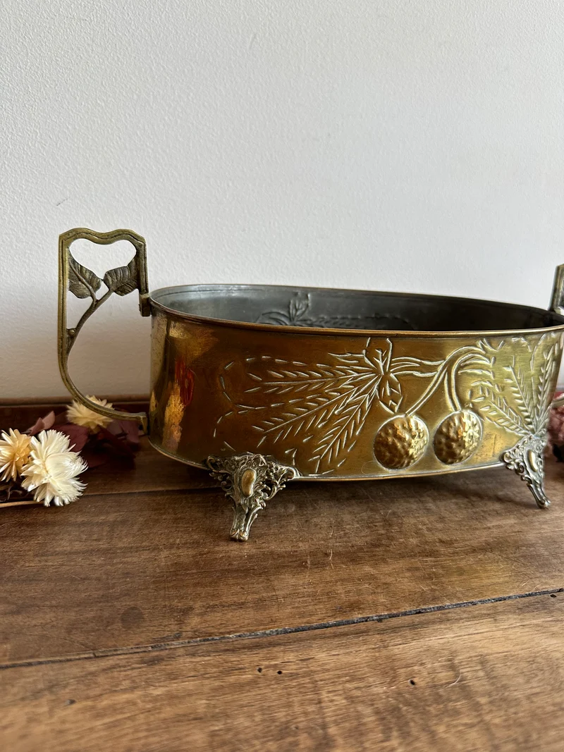Jardinière en cuivre et laiton gravée sur pieds sculptés