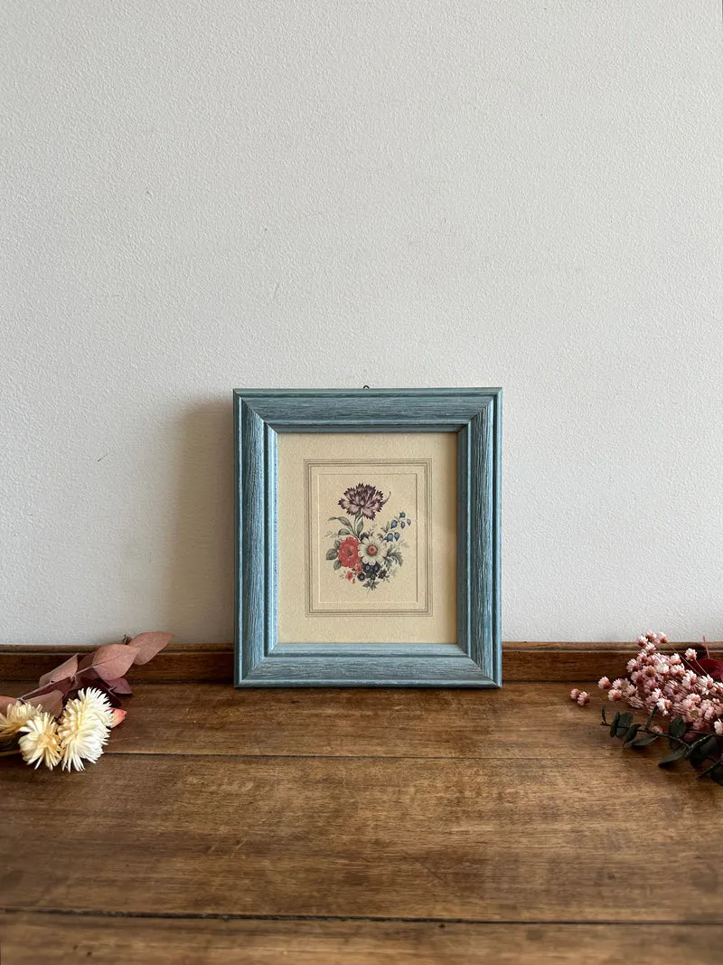 Représentation florale dans cadre en bois bleu