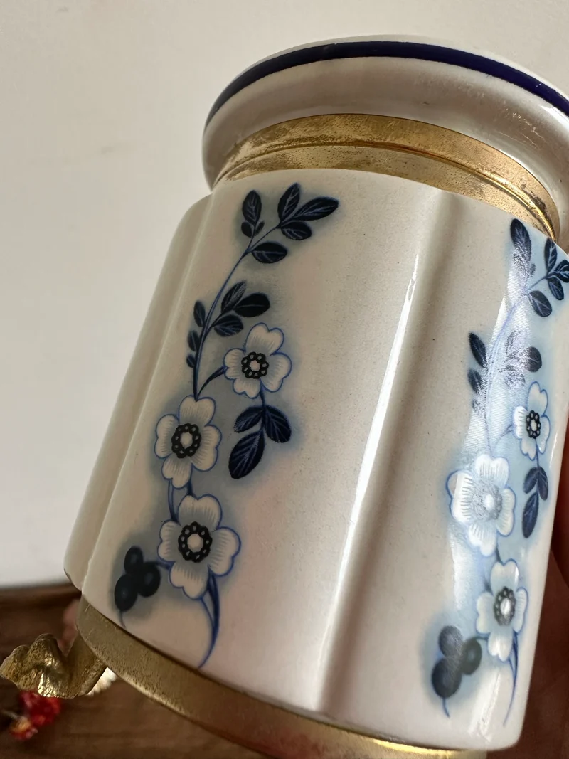 Pot en porcelaine peinte cerclé de laiton sur pieds