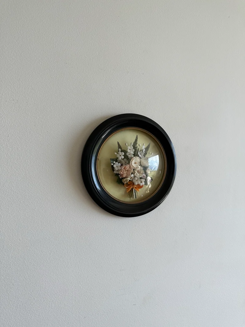 Fleurs séchées en tissu sous verre bombé rond dans cadre en bois noir