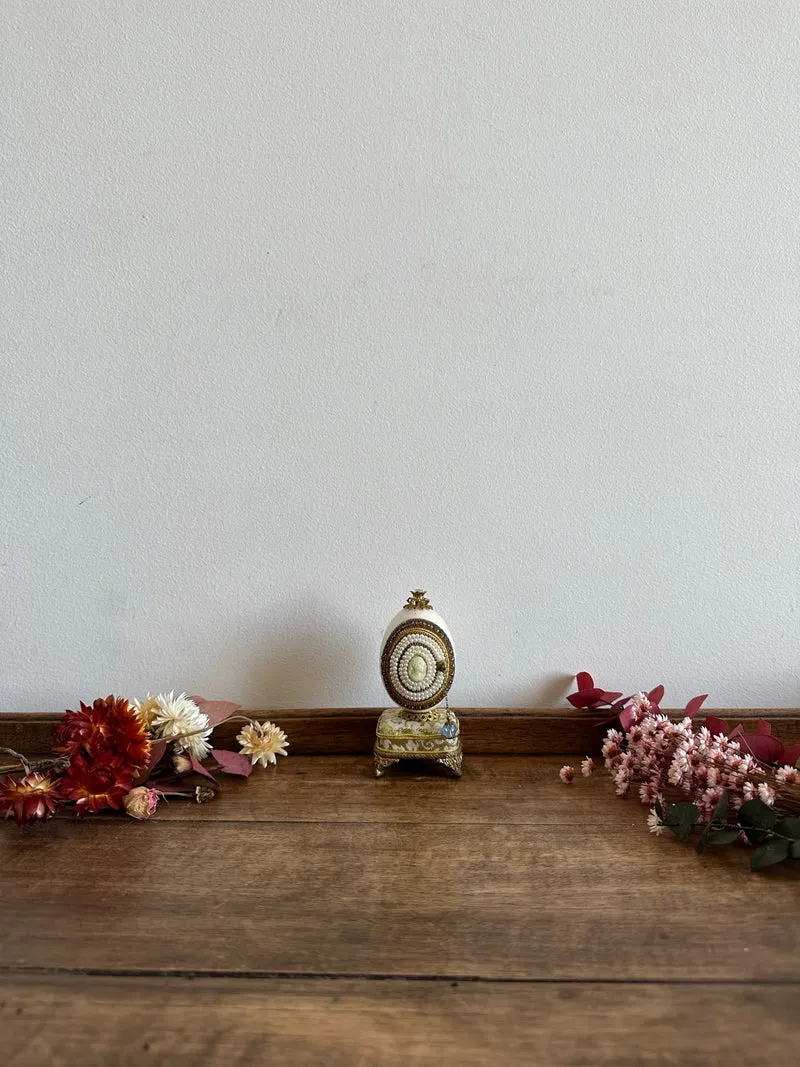 Oeuf perlé boîte à musique sur socle doré