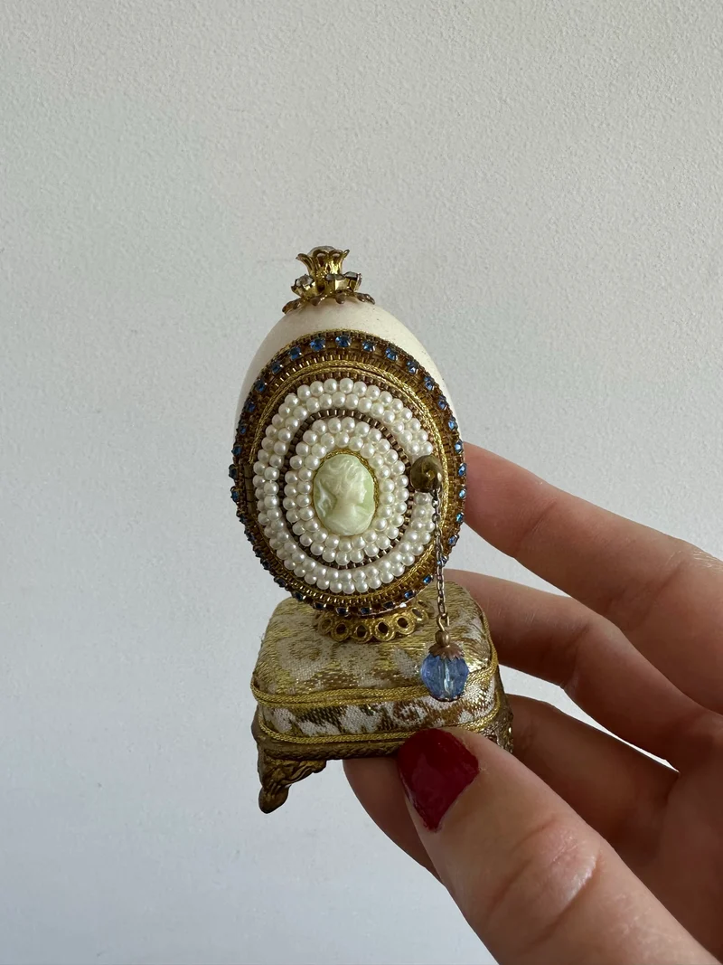 Oeuf perlé boîte à musique sur socle doré