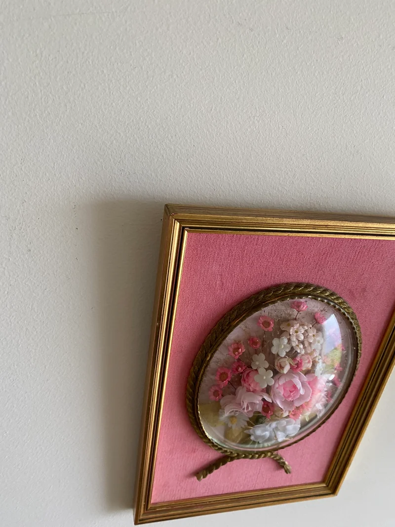 Fleurs en tissu sous verre bombé encadrées fond rose