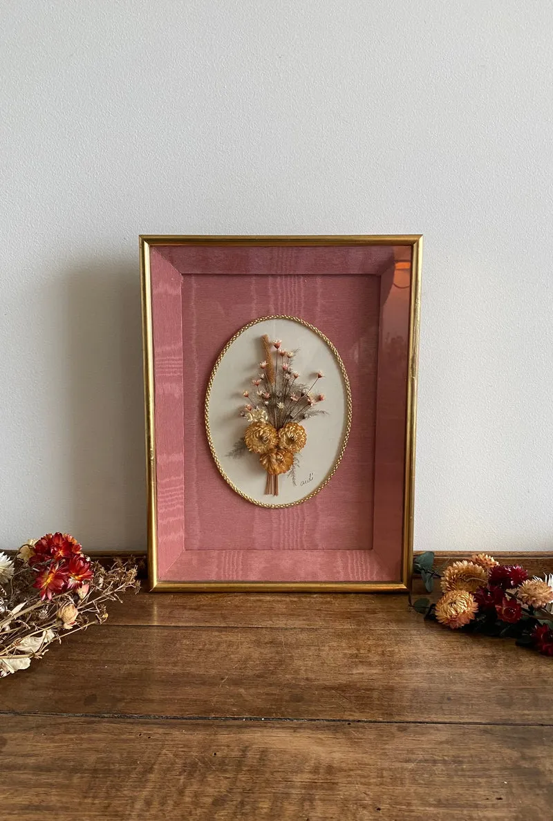 Fleurs séchées encadrées sur fond rose en tissu