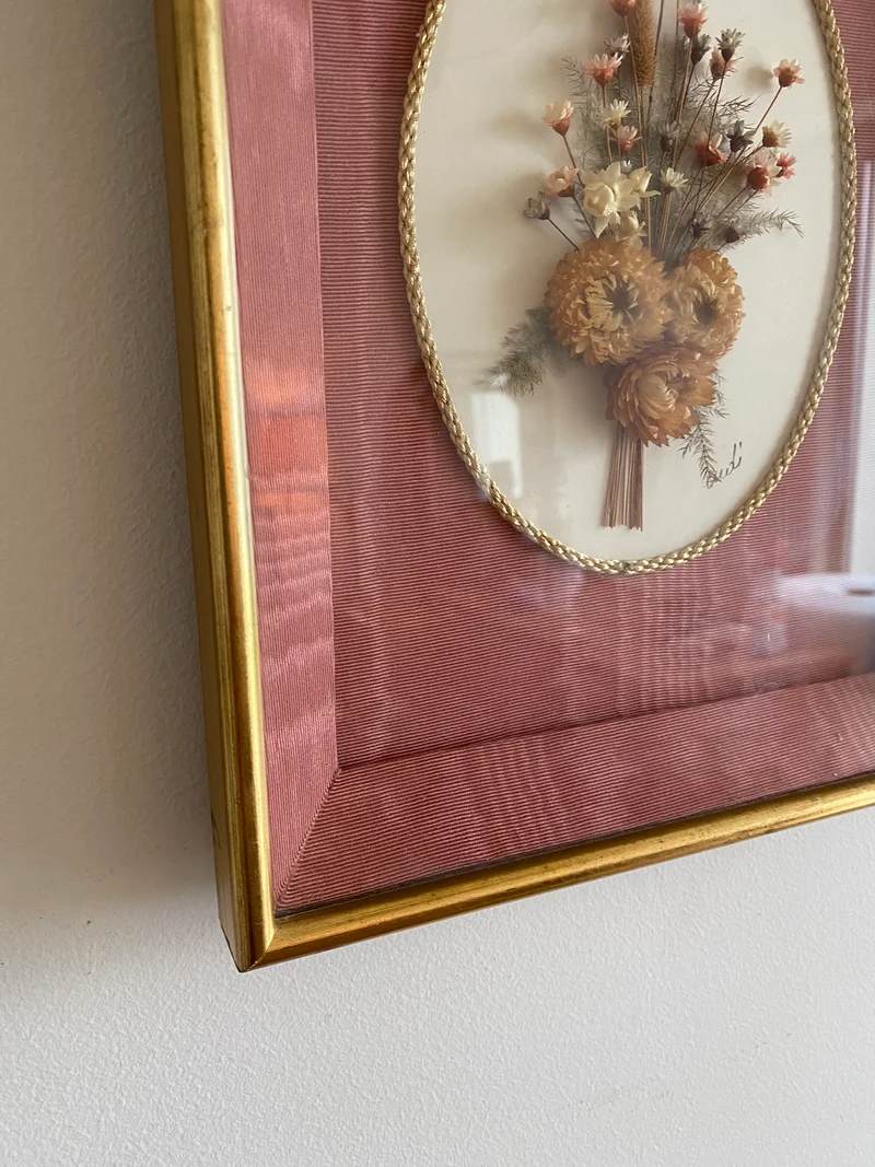 Fleurs séchées encadrées sur fond rose en tissu
