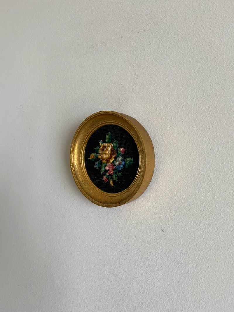 Broderie encadrée sur fond noir cadre rond doré