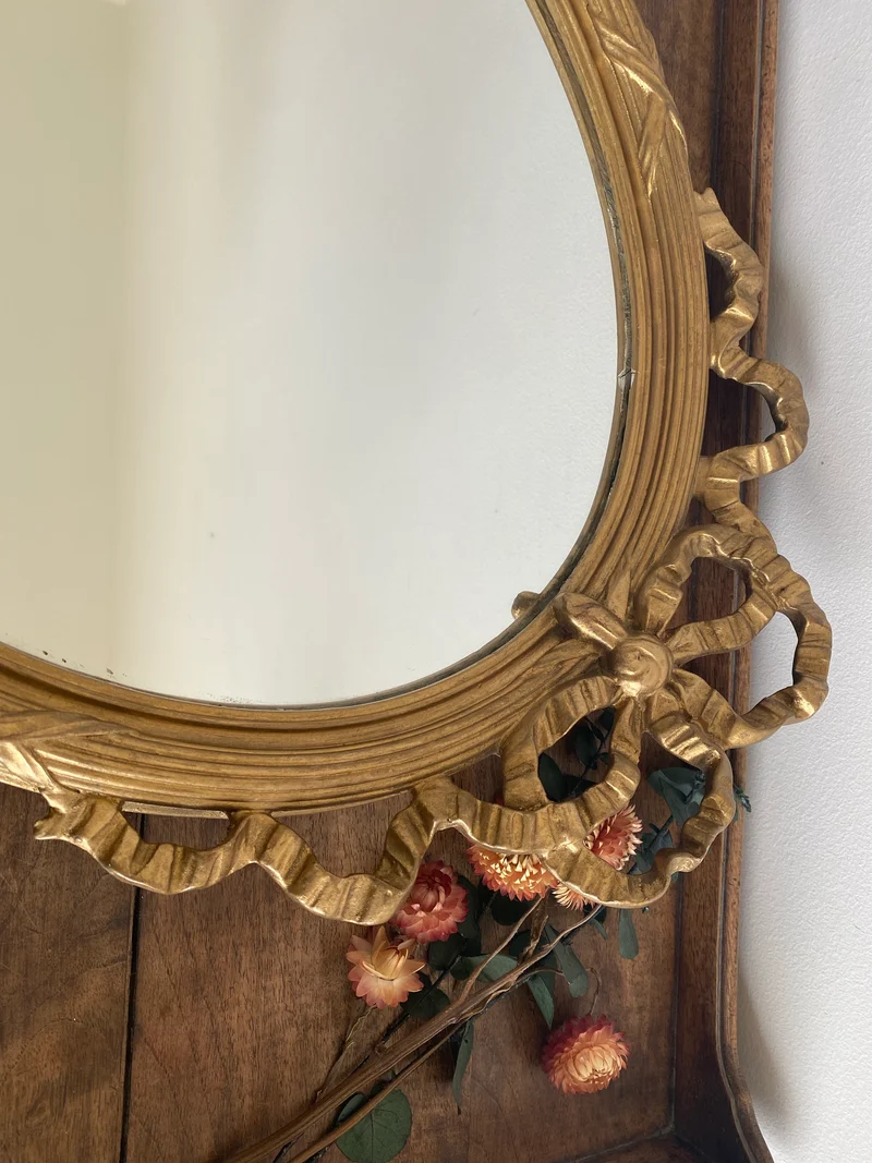 Miroir ovale en bois doré fronton noeud style Louis XVI