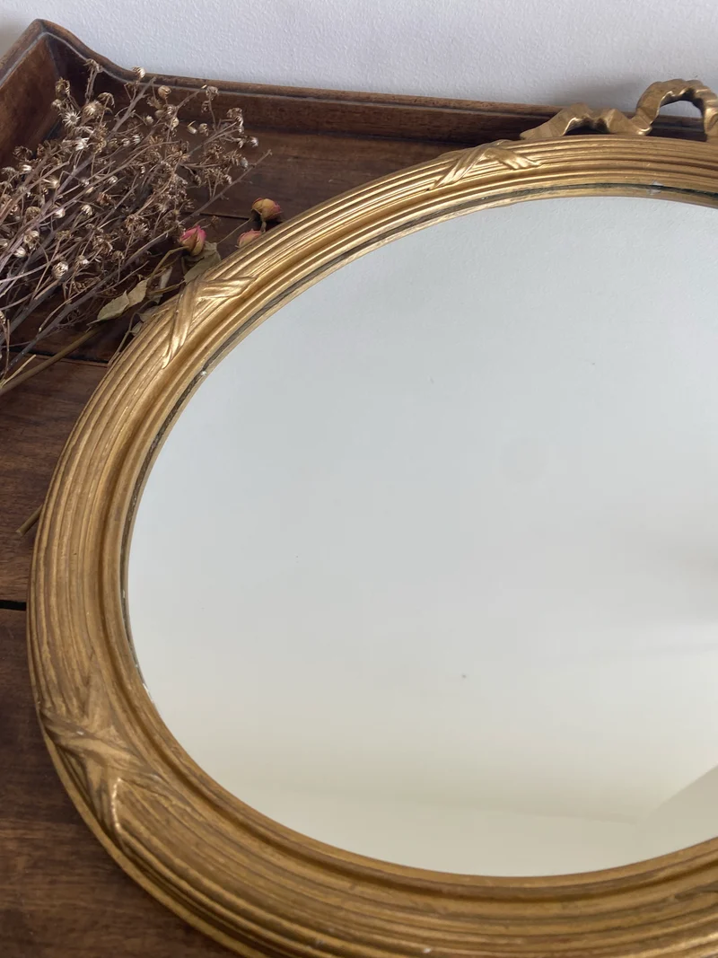 Miroir ovale en bois doré fronton noeud style Louis XVI