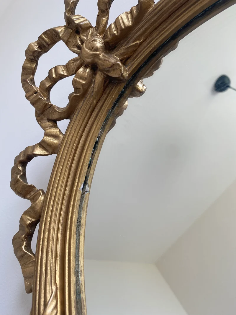 Miroir ovale en bois doré fronton noeud style Louis XVI