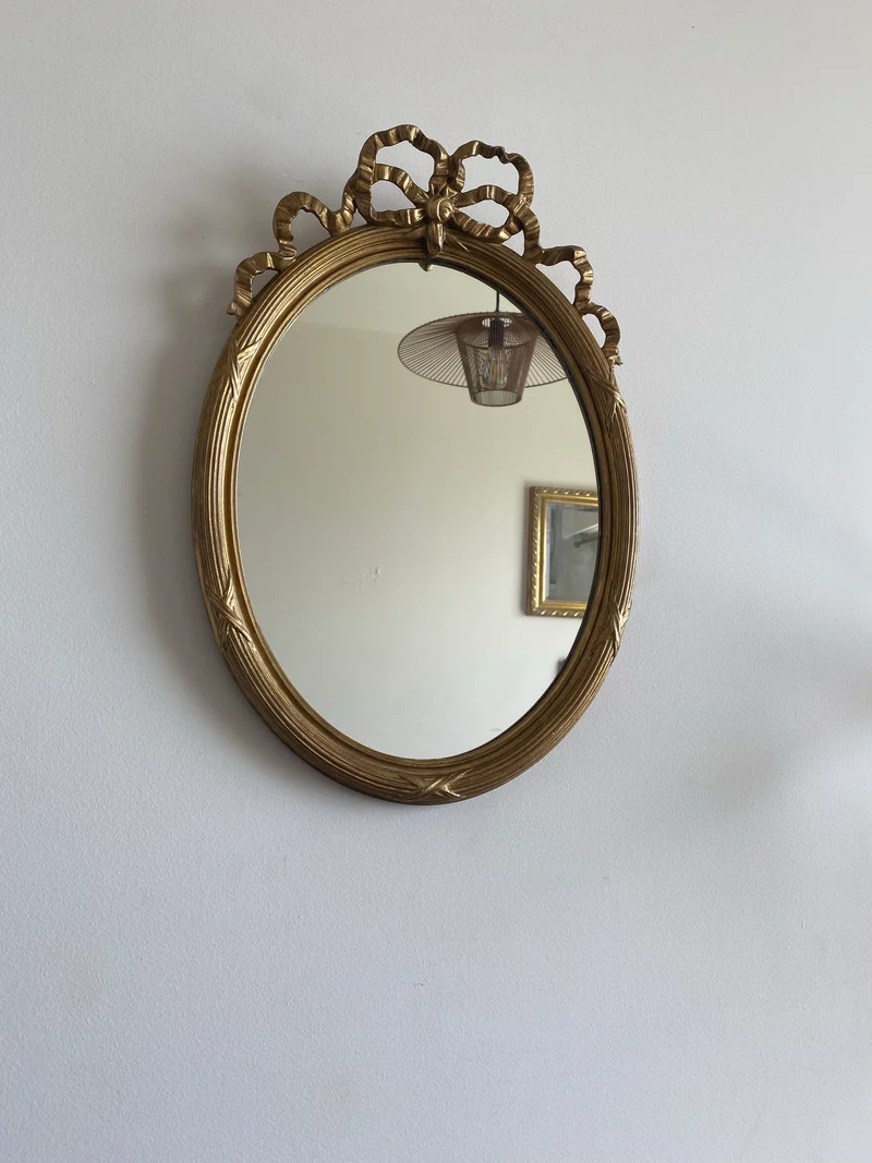 Miroir ovale en bois doré fronton noeud style Louis XVI