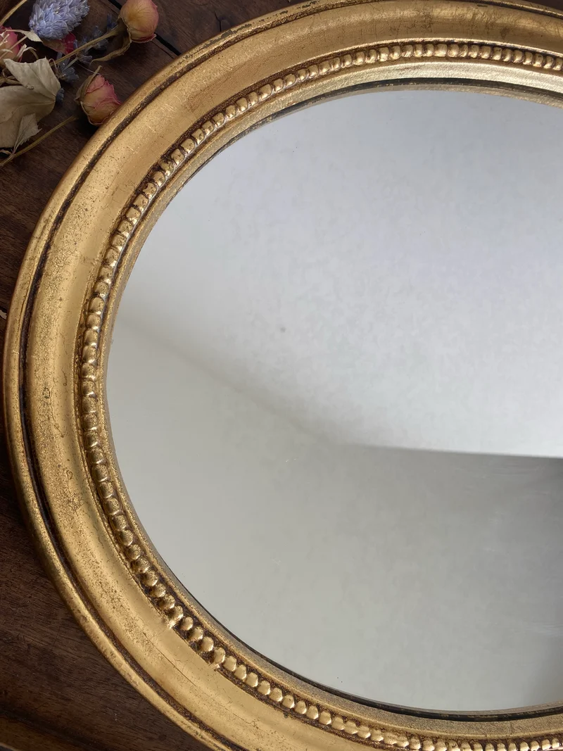 Miroir ovale en bois doré, style baroque avec nœud