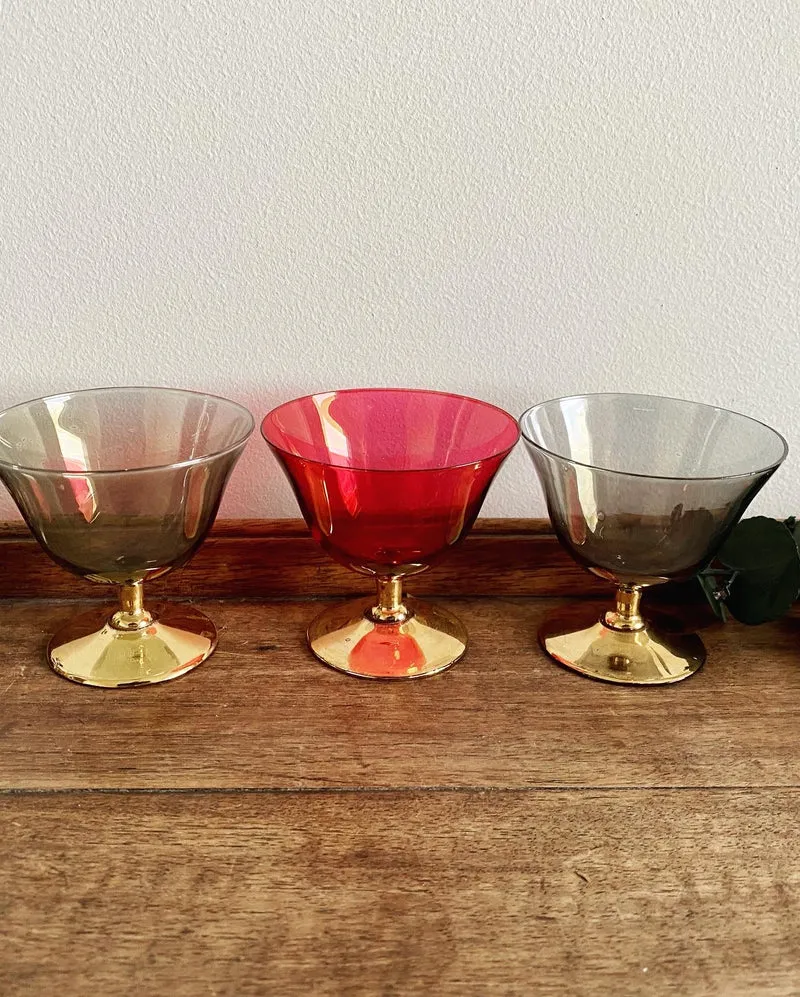 Verres à liqueur colorés sur pieds dorés.