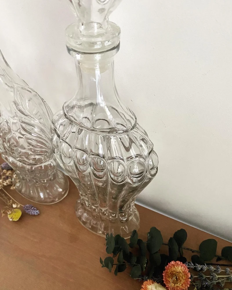 Bouteilles à liqueur anciennes en verre travaillé